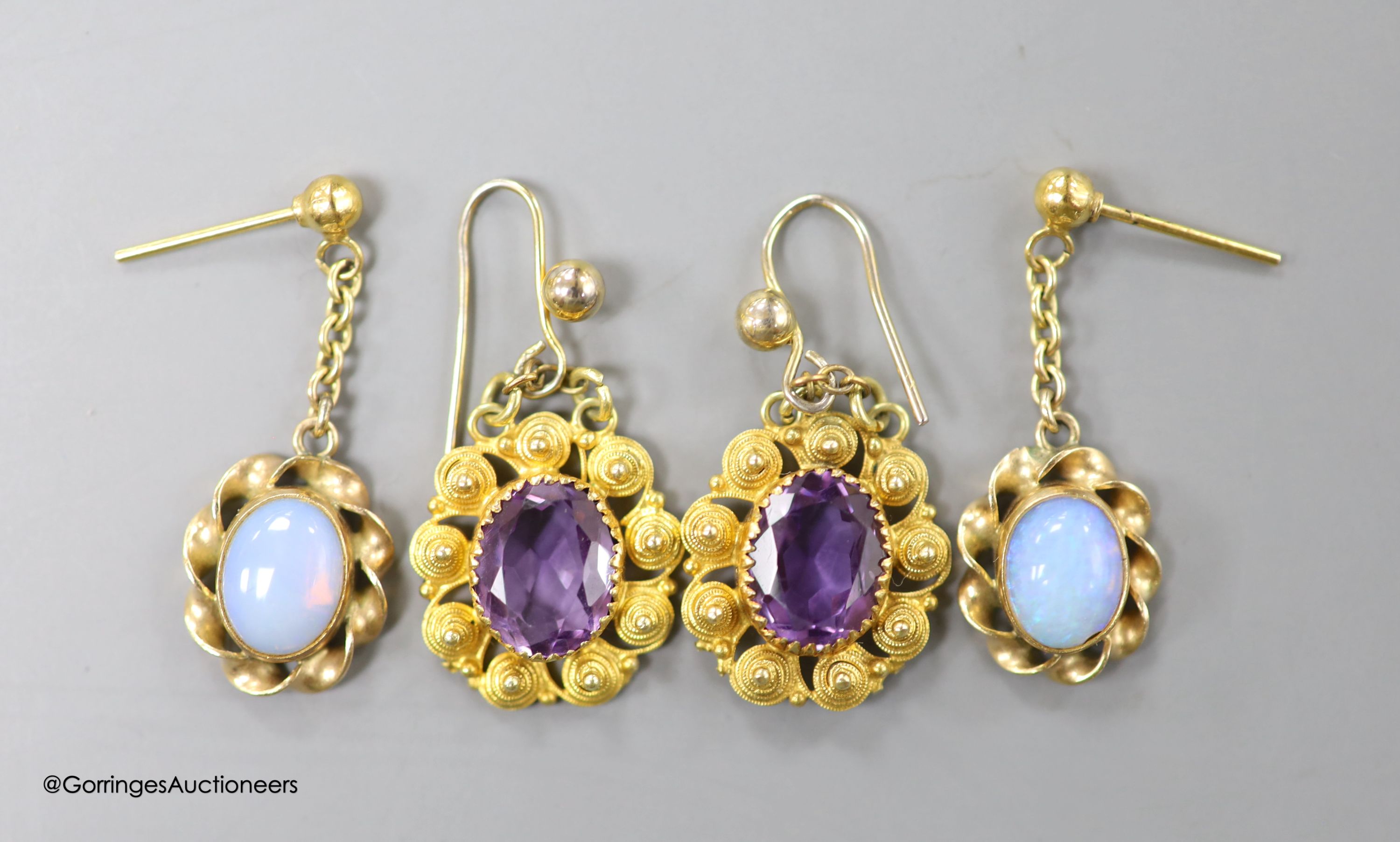 A pair of late Victorian yellow metal and amethyst set oval drop earrings, overall 24mm, and a pair of yellow metal and opal earrings